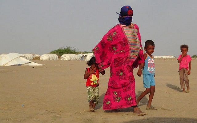 La mère d'Imad, à droite, et d'Alia, à gauche, leur tient la main alors qu'ils marchent dans le camp d' al-Waara, dans le district de Khokha, à environ 30 kilomètres de la ville de Hays, le 1er octobre 2018 (Crédit : / AFP PHOTO / NABIL HASSAN La mère d'Imad, à droite, et d'Alia, à gauche, leur tient la main alors qu'ils marchent dans le camp d' al-Waara, dans le district de Khokha, à environ 30 kilomètres de la ville de Hays, le 1er octobre 2018 (Crédit : / AFP PHOTO / NABIL HASSAN