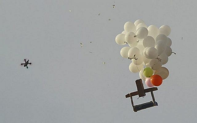 Cette photo prise au Kibbutz Nahal Oz dans le sud d'Israël montre un drone militaire israélien s'approcher de ballons transportant un dispositif incendiaire lancé depuis la bande de Gaza, le 18 octobre 2018 (Crédit : Jack Guez/AFP) Cette photo prise au Kibbutz Nahal Oz dans le sud d'Israël montre un drone militaire israélien s'approcher de ballons transportant un dispositif incendiaire lancé depuis la bande de Gaza, le 18 octobre 2018 (Crédit : Jack Guez/AFP)