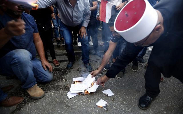 Les résidents du village druze de Majdal Shams dans le plateau du Golan, mettent le feu à de faux bulletins de vote, pour protester contre les élections municipales. le 21 ocotbre 2018. (Crédit : JALAA MAREY / AFP)