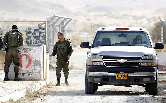 Un soldat israélien inspecte une voiture qui revient d'une plantation de poivrons au moshav Tsofar, à la frontière israélo-jordanienne, le 23 ocotbre 2018. (Crédit : JACK GUEZ / AFP)
