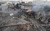 Des Palestiniens rassemblés autour des décombres d'un bâtiment de la ville de Gaza détruit par une frappe aérienne israélienne le 27 octobre 2018. (Crédit : Mahmud Hams / AFP)