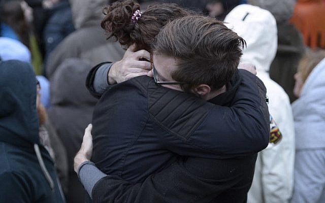 Des membres de la communauté de Squirrel Hill s'embrassent lors d'une vigile organisée par des étudiants en souvenir de ceux qui sont morts plus tôt dans la journée lors d'une fusillade à la synagogue Tree of Life dans le quartier de Squirrel Hill à Pittsburgh le 27 octobre 2018. (Crédit : Dustin Franz / AFP)