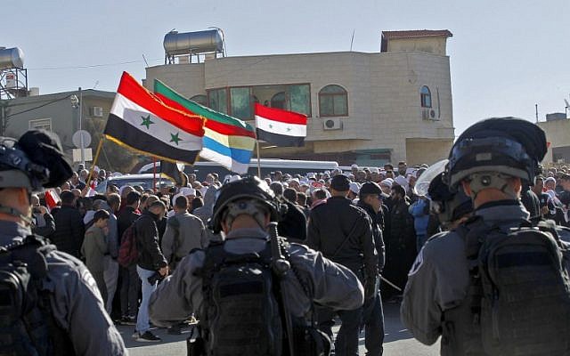 Les forces de sécurité israéliennes montent la garde pendant que les hommes druzes protestent contre les élections municipales devant un bureau de vote dans le village de Majdal Shams, le 30 octobre 2018. (Crédit : JALAA MAREY / AFP)