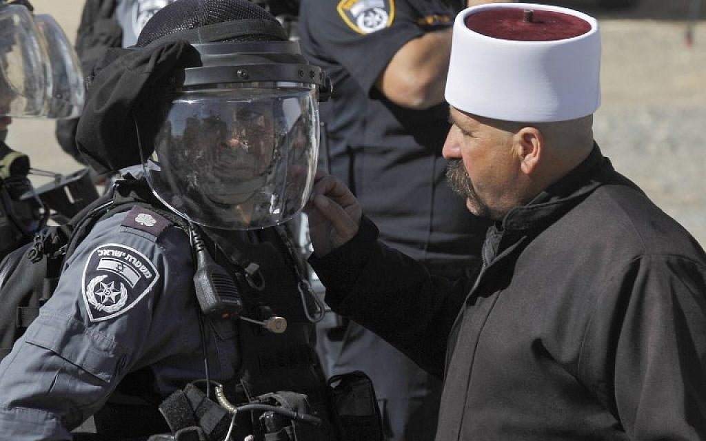 Un homme druze s'entretient avec un policier lors d'une manifestation contre les élections municipales devant un bureau de vote du village de Majdal Shams le 30 octobre 2018. (Crédit : JALAA MAREY / AFP)