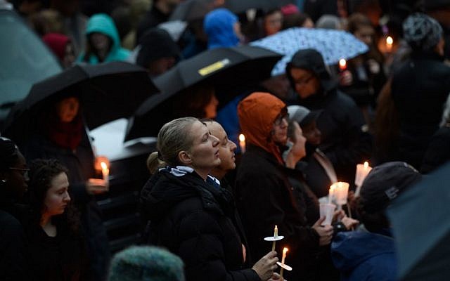 Les gens se réunissent pour une veillée interconfessionnelle à quelques blocs d'immeubles du site d'une fusillade de masse survenue à la synagogue Tree of Life de Pittsburgh, en Pennsylvanie, le 27 octobre 2018 (Crédit : Jeff Swensen/Getty Images/AFP)