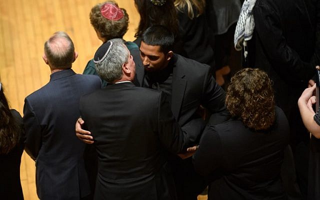 Wasi Mohamed, directeur exécutif du Centre islamique de Pittsburgh, est pris dans les bras par un rabbin après s'être adressé à l'auditoire au cours d'une cérémonie en l'honneur des victimes de la fusillade de samedi à la synagogue Tree Of Life. (Crédit : Jeff Swensen / Getty Images / AFP)