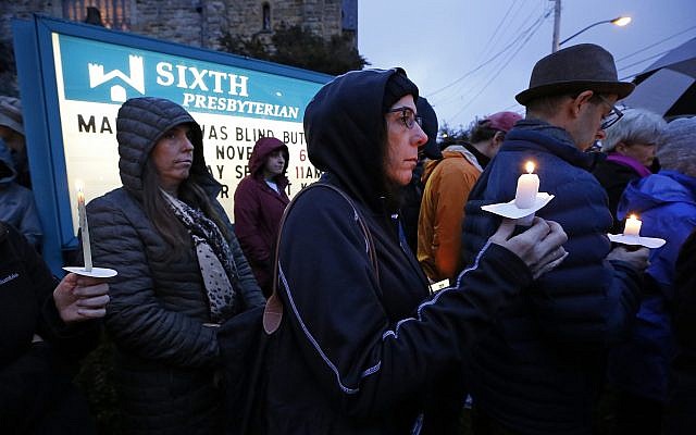 Une foule avec des bougies sur la pelouse de la sixième église presbytérienne à l'intersection de Murray Ave. et Forbes Ave. dans le quartier de Squirrel Hill à Pittsburgh, en Pennsylvanie, lors de la veillée commémorative en l'honneur des victimes de la fusillade dans la synagogue Tree of life, où un homme armé a tué 11 fidèles dans la journée du samedi 27 octobre 2018. (Crédit : AP Photo / Gene J. Puskar)