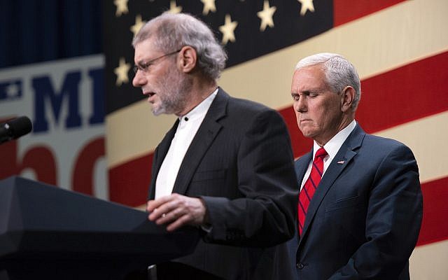 Le vice-président Mike Pence, à droite, prie avec le "rabbin" Loren Jacobs, pour les victimes de la fusillade de la synagogue de Pittsburgh lors d'un rassemblement républicain à Waterford, dans le Michigan (Crédit : Tanya Moutzalias/Ann Arbor News-MLive.com via AP)