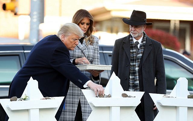 Le président américain et son épouse Melania déposent une gerbe de fleurs à Pittsburgh pour rendre hommage aux victimes de la fusillade de la synagogue Tree of Life, en présence du rabbin Jeffrey Myers, le 30 octobre 2018 (Crédit : AP/Keith Srakocic /Andrew Harnik) Le président américain et son épouse Melania déposent une gerbe de fleurs à Pittsburgh pour rendre hommage aux victimes de la fusillade de la synagogue Tree of Life, en présence du rabbin Jeffrey Myers, le 30 octobre 2018 (Crédit : AP/Keith Srakocic /Andrew Harnik)