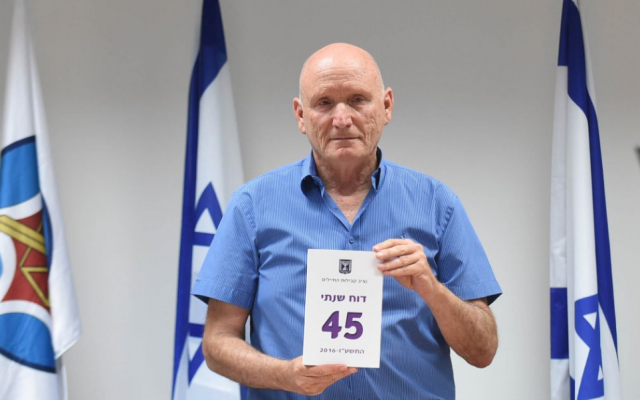Le médiateur de l'armée israélienne Yitzhak Brick pose avec une copie de son rapport annuel le 28 mai 2017. (Ministère de la Défense)