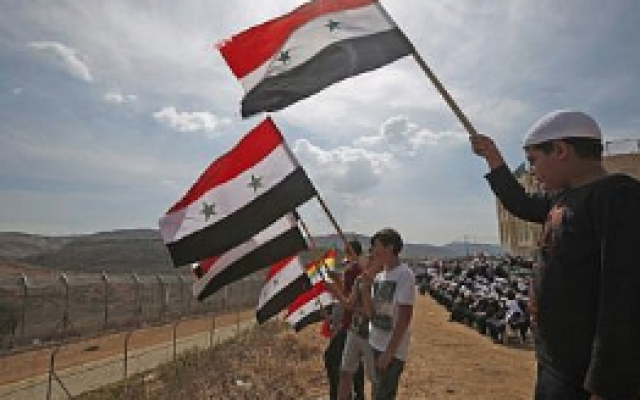 De jeunes membres de la communauté druze brandissent des drapeaux syriens lors d'un rassemblement dans le village druze de Majdal Shams, sur les hauteurs du Golan, le 6 octobre 2018, à l'occasion du 45e anniversaire de la guerre israélo-arabe de 1973 (AFP PHOTO / JALAA MAREY)