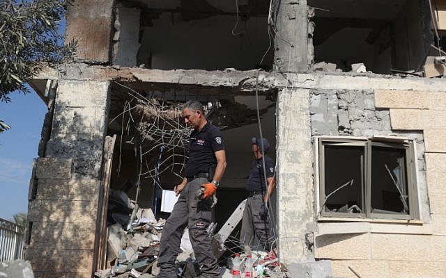 Les forces de sécurité israéliennes inspectent une maison frappée par une roquette lancée depuis la bande de Gaza à Beer Sheva, dans le sud d'Israël, le 17 octobre 2018 (Crédit : Yonatan Sindel/Flash90) Les forces de sécurité israéliennes inspectent une maison frappée par une roquette lancée depuis la bande de Gaza à Beer Sheva, dans le sud d'Israël, le 17 octobre 2018 (Crédit : Yonatan Sindel/Flash90)