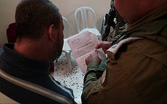 L'armée israélienne a remis au parents d'Ashraf Na'alowa, l'auteur présumé de l'attentat de Barkan, un ordre de démolition pour sa maison, le 15 octobre 2018. (Crédit : unité du porte-parole de l'armée israélienne)