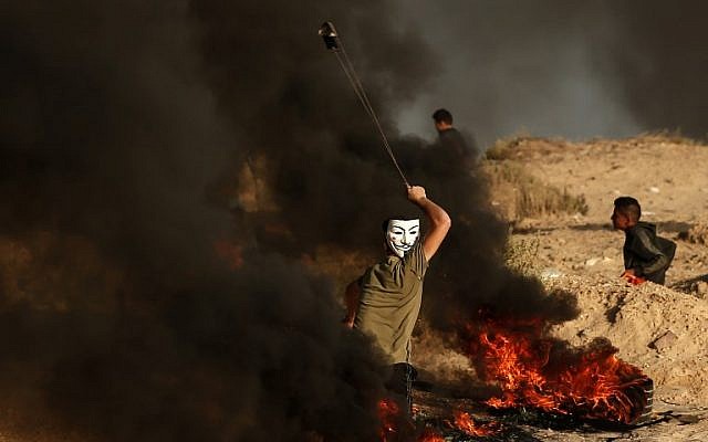 Photo d'illustration : Un Palestinien utilise une fronde pour jeter des pierres lors d'un affrontement près de la frontière avec Israël, sur une plage, à Beit Lahia, dans le nord de la bande de Gaza, le 28 octobre 2018 (Crédit :Mahmud Hams/AFP) Photo d'illustration : Un Palestinien utilise une fronde pour jeter des pierres lors d'un affrontement près de la frontière avec Israël, sur une plage, à Beit Lahia, dans le nord de la bande de Gaza, le 28 octobre 2018 (Crédit :Mahmud Hams/AFP)