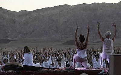 Des yogis, israéliens et étrangers, participent au festival annuel de yoga d'Arava dans le secteur des anciennes mines de cuivre dans la vallée de Timna, dans la région d'Arava, dans le sud d'Israël, le 2 novembre 2018 (Crédit : MENAHEM KAHANA / AFP)