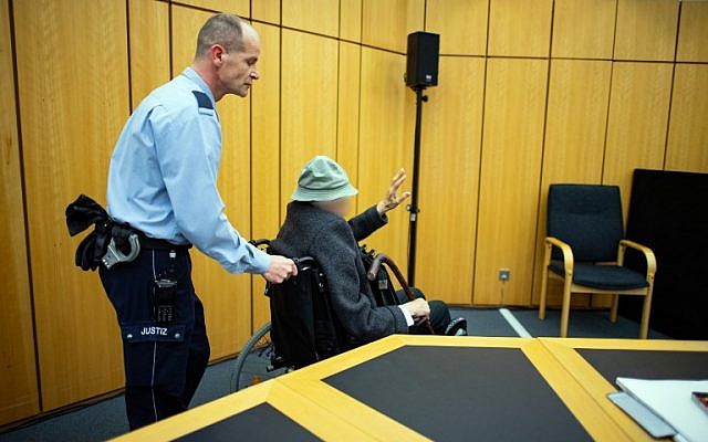 Un policier pousse un ex-garde de camp nazi de 94 ans dans un tribunal de Munster, en Allemagne, le 6 novembre 2018. (Crédit ! Guido Kirchner/dpa/AFP) Un policier pousse un ex-garde de camp nazi de 94 ans dans un tribunal de Munster, en Allemagne, le 6 novembre 2018. (Crédit ! Guido Kirchner/dpa/AFP)