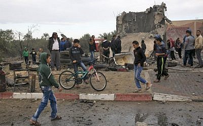 Des Palestiniens près des décombres d'un immeuble qui aurait été détruit par une frappe israélienne à Khan Younès, dans le sud de la bande de Gaza, le 12 novembre 2018 (Crédit : SAID KHATIB / AFP)