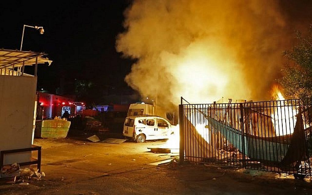 Les forces de sécurité et les pompiers israéliens se rassemblent près d'un bâtiment incendié après avoir été touché par une roquette tirée depuis l'enclave palestinienne dans la ville de Sdérot, dans le sud du pays, le 12 novembre 2018. (Crédit : Jack GUEZ / AFP)