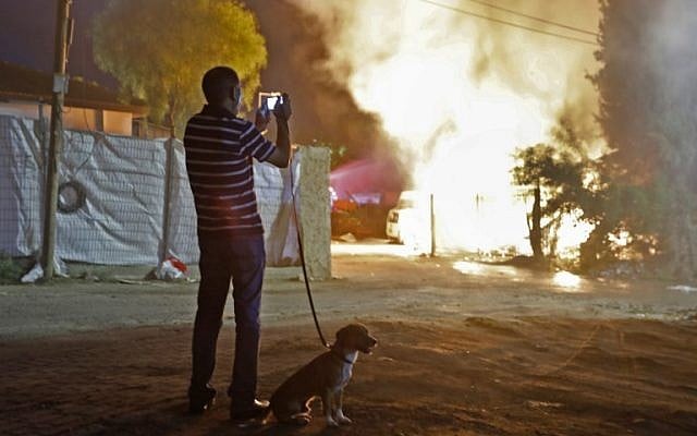 Un homme observe un bâtiment qui a été incendié après avoir été touché par une roquette tirée depuis la bande de Gaza, dans la ville de Sdérot, dans le sud d'Israël, le 12 novembre 2018. (Crédit : Menahem KAHANA / AFP) Un homme observe un bâtiment qui a été incendié après avoir été touché par une roquette tirée depuis la bande de Gaza, dans la ville de Sdérot, dans le sud d'Israël, le 12 novembre 2018. (Crédit : Menahem KAHANA / AFP)