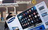 Sur cette photo prise le 28 novembre 2014, Umer Gonzalez, adepte des soldes du Black Friday, emporte son téléviseur grand écran Samsung acheté dans un Walmart à Fairfax, en Virginie. (Photo par Paul J. RICHARDS / AFP)