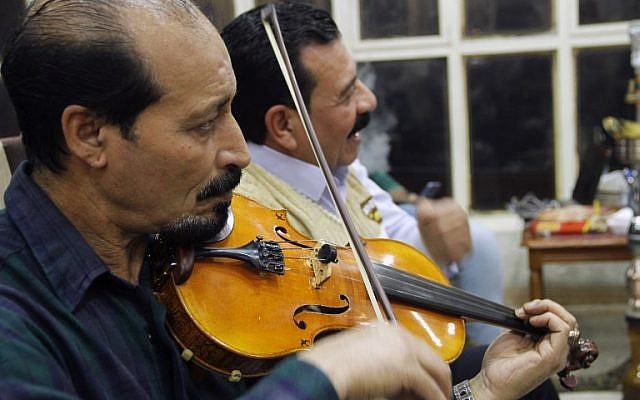 Des irakiens jouent et écoutent de la musique dans un café de Mossoul, le 6 novembre 2018. (Crédit : Zaid AL-OBEIDI / AFP) Waleed AL-KHALID / AFP) Des irakiens jouent et écoutent de la musique dans un café de Mossoul, le 6 novembre 2018. (Crédit : Zaid AL-OBEIDI / AFP) Waleed AL-KHALID / AFP)