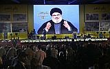Hassan Nasrallah, chef du Hezbollah, prononce un discours diffusé sur écran géant lors d'un rassemblement marquant le 12e anniversaire de la guerre Israël-Hezbollah de 2006, le 14 août 2018, à Beyrouth, Liban. (AP Photo/Hussein Malla)