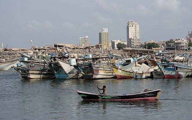 Un bateau de pêcheurs navigue devant le port d'Hodeida. En arrière-plan, des immeubles détruits par la coalition soutenue par l'Arabie saoudite et les Emirats arabes unis, le 28 septembre 2018 (Crédit : AP/Hani Mohammed) Un bateau de pêcheurs navigue devant le port d'Hodeida. En arrière-plan, des immeubles détruits par la coalition soutenue par l'Arabie saoudite et les Emirats arabes unis, le 28 septembre 2018 (Crédit : AP/Hani Mohammed)