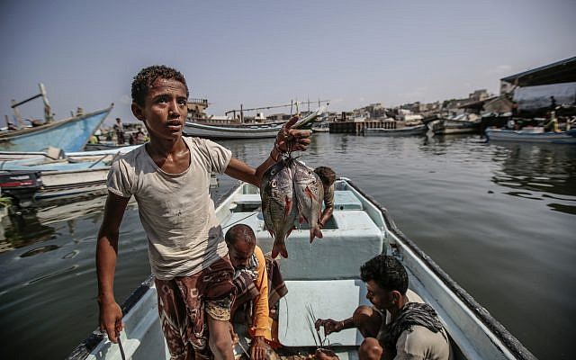 Des enfants pêchent au port d'Hodeida, au Yémen, le 29 septembre 2018. (Crédit :  AP/Hani Mohammed)