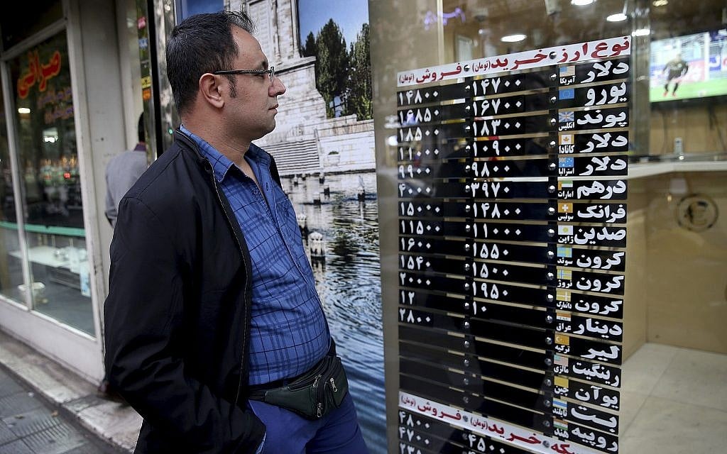 Un Iranien regarde le taux de change à travers la vitrine d'une boutique du centre de Téhéran, en Iran, le 5 novembre 2018 (Crédit : AP/Ebrahim Noroozi) Un Iranien regarde le taux de change à travers la vitrine d'une boutique du centre de Téhéran, en Iran, le 5 novembre 2018 (Crédit : AP/Ebrahim Noroozi)