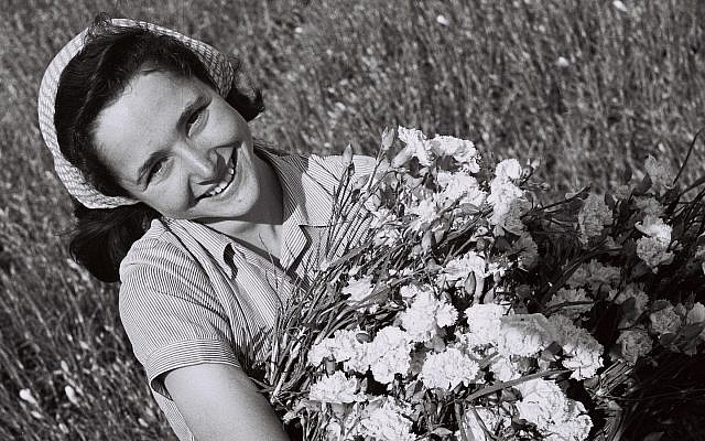 Une fille avec un bouquet d'œillets dans un champ au moshav Mishmar Hasharon (GPO, Public Domain/Wikimedia Commons)