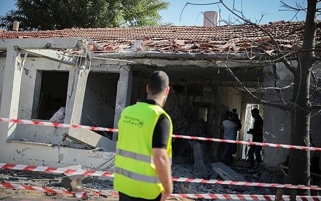 Des personnes se rassemblent devant une maison touchée par une roquette tirée depuis la bande de Gaza dans la ville d'Ashkelon, dans le sud d'Israël, le 13 novembre 2018 (Crédit : Hadas Parush / Flash90). Des personnes se rassemblent devant une maison touchée par une roquette tirée depuis la bande de Gaza dans la ville d'Ashkelon, dans le sud d'Israël, le 13 novembre 2018 (Crédit : Hadas Parush / Flash90).