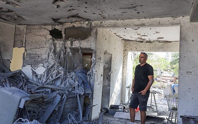 Un homme debout à l'intérieur d'une maison qui a été touchée par une roquette tirée depuis la bande de Gaza dans la ville d'Ashkelon, au sud d'Israël, le 13 novembre 2018 (Crédit : Nati Shohat/Flash90) Un homme debout à l'intérieur d'une maison qui a été touchée par une roquette tirée depuis la bande de Gaza dans la ville d'Ashkelon, au sud d'Israël, le 13 novembre 2018 (Crédit : Nati Shohat/Flash90)