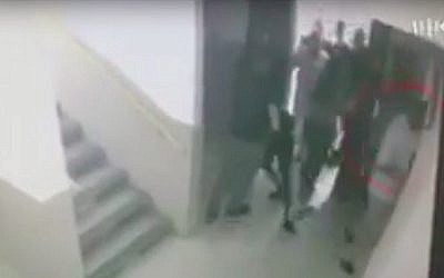 Des inspecteurs de police interpellent un lycéen israélien d'origine éthiopienne à Ashdod, sous le regard du directeur de l'école. (Crédit : Kan)