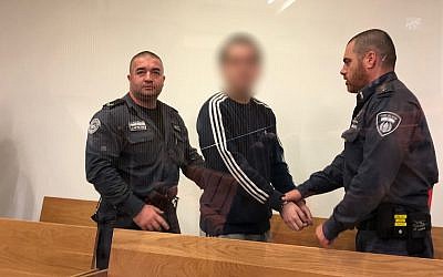 M., un Israélo-américain reconnu coupable d'avoir fait de fausses alertes à la bombe contre des centres communautaires juifs et d'autres cibles à travers le monde, arrive devant le tribunal de district de Tel Aviv le 22 novembre 2018 pour sa sentence. (Jacob Magid/Times of Israel)