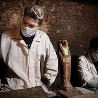 Des archéologues travaillent sur des artefacts retrouvés dans une tombe des pyramides de Saqqara, le 10 novembre 2018. (Crédit : Nariman El-Mofty/AP) Des archéologues travaillent sur des artefacts retrouvés dans une tombe des pyramides de Saqqara, le 10 novembre 2018. (Crédit : Nariman El-Mofty/AP)