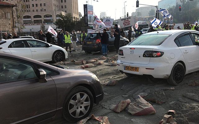 Les employés de l'usine Hartuv déversent des sacs de ciment à l'entrée de Jérusalem, bloquant la route de la ville, le 25 novembre 2018 (Crédit : Unité du porte-parole de la police israélienne) Les employés de l'usine Hartuv déversent des sacs de ciment à l'entrée de Jérusalem, bloquant la route de la ville, le 25 novembre 2018 (Crédit : Unité du porte-parole de la police israélienne)