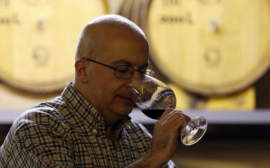 Alaa Mansur, directeur de la production au vignoble Haddad, goûte un échantillon a l'Eagle Distilleries, en Jordanie, le 31 octobre, 2018. (Crédit : KHALIL MAZRAAWI / AFP)