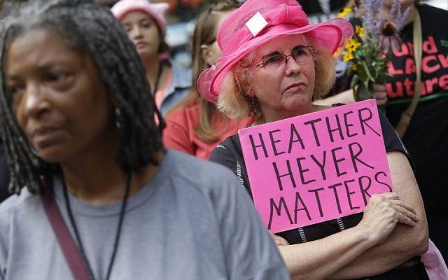 (FILES) Une femme brandit une pancarte à la mémoire de Heather Heyer à une veillée à Chicago en mémoire des victimes des affrontements du jour précédent à Charlottesville, Virginie. (Photo by Joshua Lott / AFP) (FILES) Une femme brandit une pancarte à la mémoire de Heather Heyer à une veillée à Chicago en mémoire des victimes des affrontements du jour précédent à Charlottesville, Virginie. (Photo by Joshua Lott / AFP)