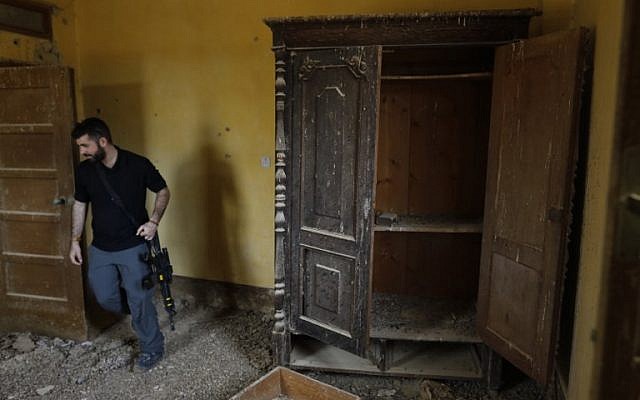 Un agent de sécurité israélien inspecte l'intérieur d'une église éthiopienne à Qasr al- Yahud, en Cisjordanie, le 9 décembre 2018. (Crédit : MENAHEM KAHANA / AFP) Un agent de sécurité israélien inspecte l'intérieur d'une église éthiopienne à Qasr al- Yahud, en Cisjordanie, le 9 décembre 2018. (Crédit : MENAHEM KAHANA / AFP)