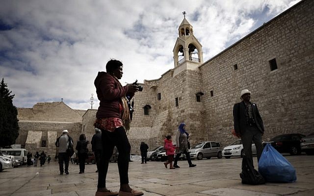 Touristes et pèlerins chrétiens se photographient devant l'Eglise de la Nativité en Cisjordanie, le 12 décembre 2018. (Crédit : THOMAS COEX / AFP) Touristes et pèlerins chrétiens se photographient devant l'Eglise de la Nativité en Cisjordanie, le 12 décembre 2018. (Crédit : THOMAS COEX / AFP)