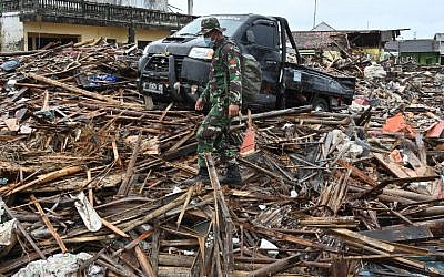 Un soldat marche dans les débris laissés par le tsunami en Indonésie le 25 décembre 2018, (Crédit : Adek BERRY / AFP)