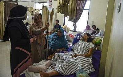 Des Indonésiens visitent une proche blessée dans par le tsunami, le 25 décembre 2018. -(Crédit :MOHD RASFAN / AFP)