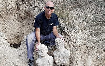 Nir Distelfeld, inspecteur de l'Unité de prévention des vols de l'Autorité israélienne des antiquités, avec les  deux bustes funéraires en calcaire qui ont été découverts après les fortes pluies du mois de décembre dans la région de Beit Shean par une randonneuse (Crédit : Eitan Klein, Autorité israélienne des antiquités)