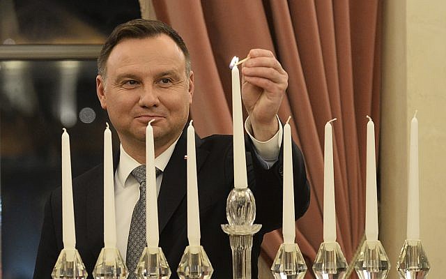 Le président polonais Andrzej Duda allume la dernière bougie pour Hanoukka au palais présidentiel de Varsovie, en Pologne, le 9 décembre 2018 (Crédit :  lAP Photo/Alik Keplicz)