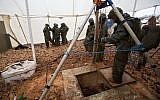 Des soldats israéliens se tiennent autour de l'ouverture qui mène à un tunnel qui, selon l'armée, a été creusé par l'organisation terroriste du Hezbollah à la frontière entre Israël et le Liban, près de Metulla, le 19 décembre 2018. (AP Photo/Sebastian Scheiner)