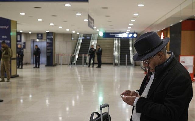 Un voyageur regarde son smartphone à l'aéroport d'Orly, au sud de Paris, le 18 mars 2017 (Crédit : AP Photo/Kamil Zihnioglu)