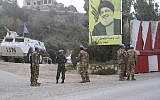 Des soldats de la paix indonésiens de l'ONU devant une affiche du leader du Hezbollah, Sheikh Hassan Nasrallah, lors d'une patrouille du côté libanais de la frontière israélo-libanaise dans le village de  Kfar Kila, au sud du Liban, le 4 décembre 2018 (Crédit : AP/Mohammed Zaatari)