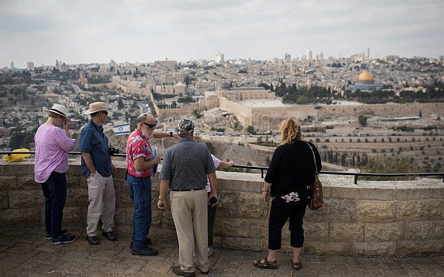 Des touristes écoutent un guide sur le belvédère du Mont des Oliviers surplombant la Vieille Ville de Jérusalem, le 11 octobre 2018. (Hadas Parush/Flash90)