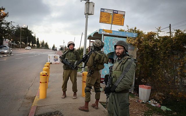 Des soldats israéliens montent la garde à un carrefour de Cisjordanie suite à un attentat terroriste, le 13 décembre 2018 (Crédit :Gershon Elinson/Flash90) Des soldats israéliens montent la garde à un carrefour de Cisjordanie suite à un attentat terroriste, le 13 décembre 2018 (Crédit :Gershon Elinson/Flash90)