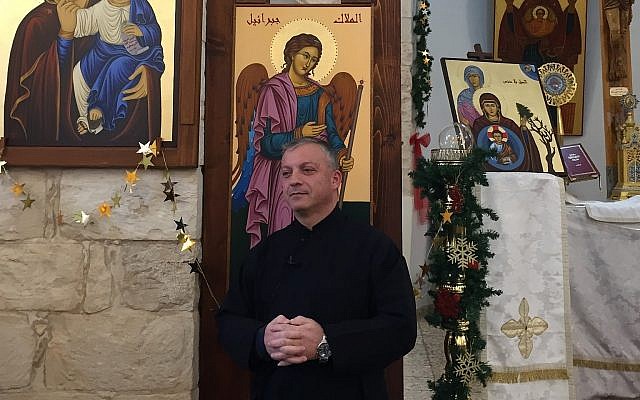 Le père Michael Assi dans l'église Mar Elias de Fassuta. (Crédit : Federico Maccioni/ Times of Israel)